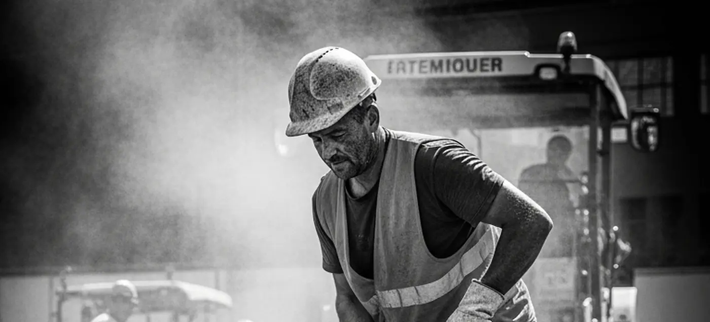 Bauarbeiter verteilt frischen Asphalt